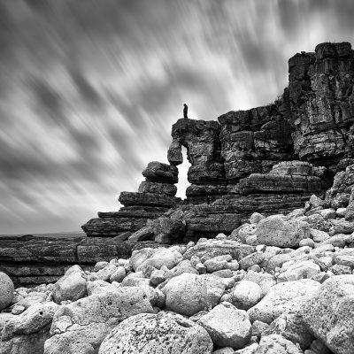 lonely sad man standing over the rocks